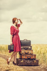 Redhead girl with suitcases at outdoor