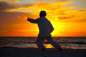 Chinese Elderly Woman Performing Taichi Outdoor by the beach und