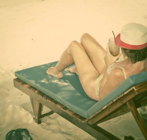 Woman sunbathing on beach chair, Thailand - retro style postcard