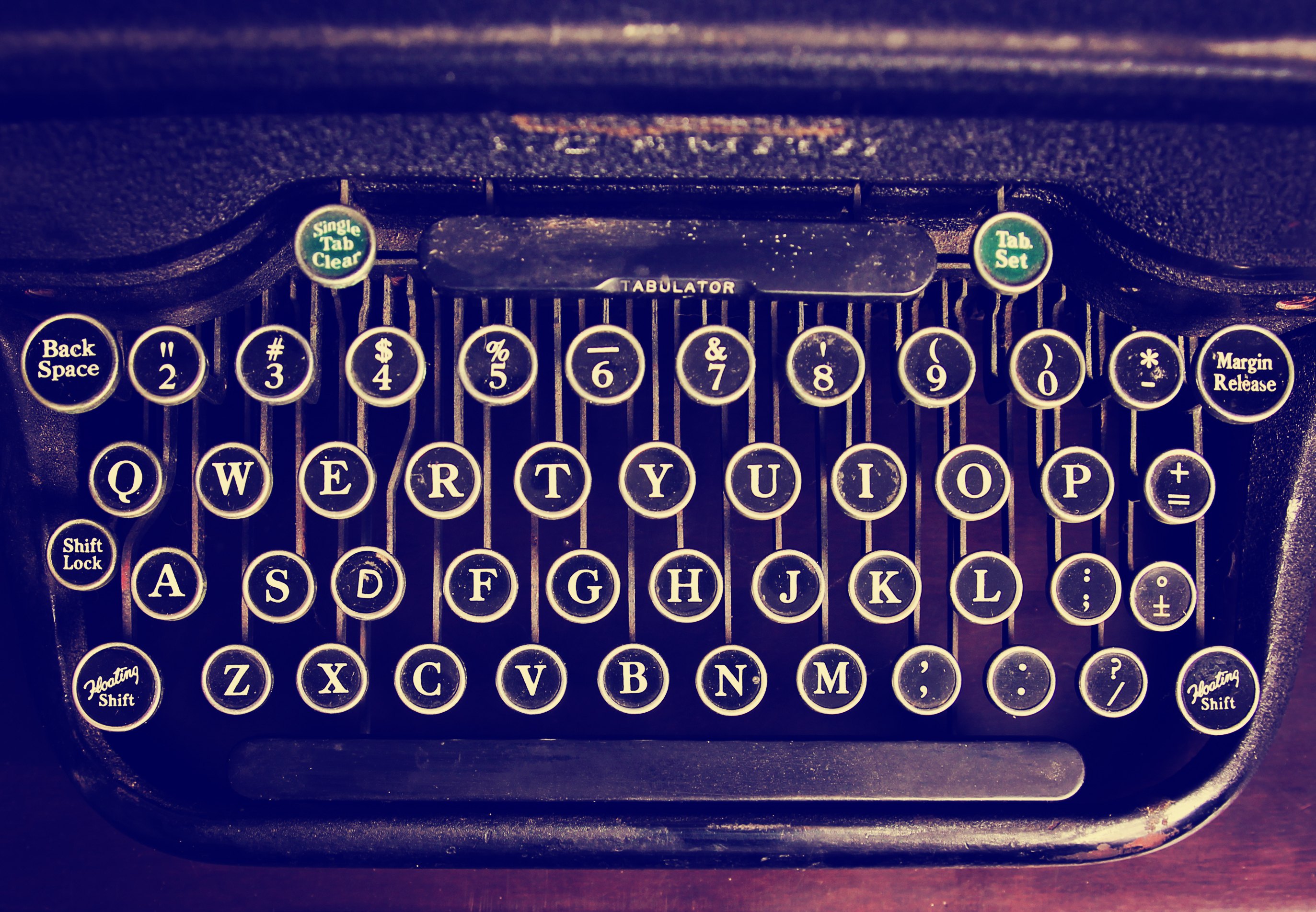 an antique typewriter on a wooden table toned with a retro vintage instagram filter effect app or action
