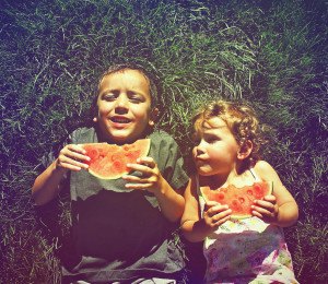 two kids eating watermelon done with a retro vintage instagram filter