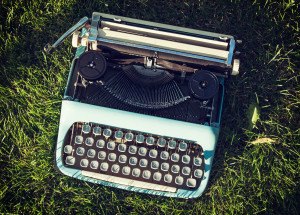 Old typewriter on the grass. Retro style.
