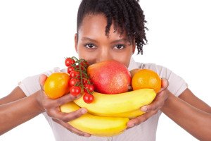 Young Happy Black / African American Woman Holding Fresh Fruits