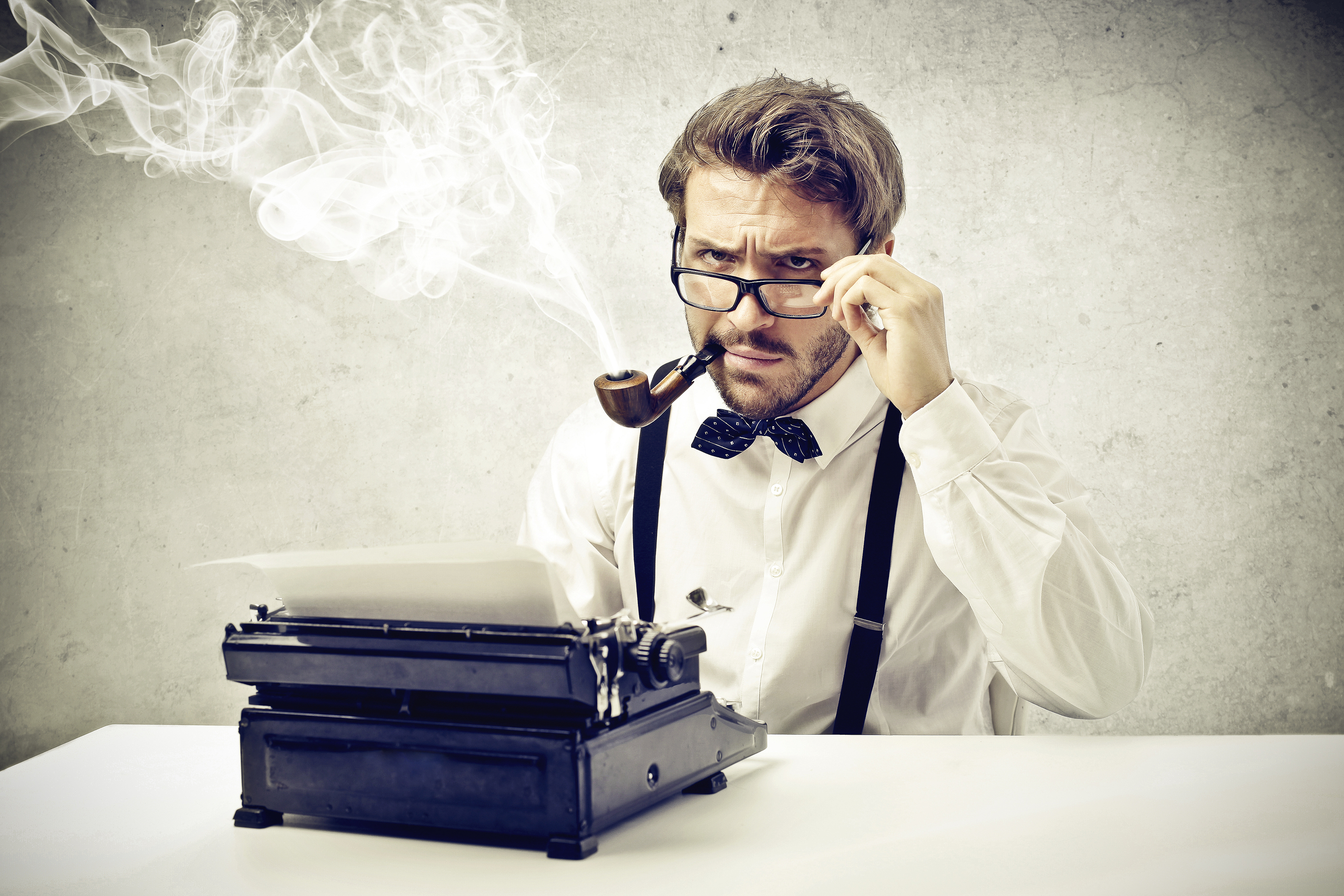 writer smokes a pipe and writes with typewriter