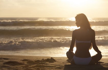 A relaxed sexy young brunette woman or girl wearing a bikini sit