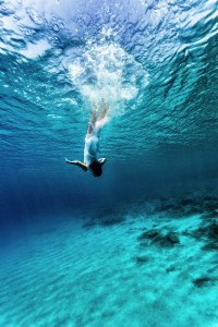 Active young female dancing underwater, enjoying summer vacation