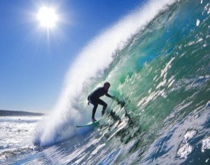 Backlit Surfer on Big Wave in the Tube on a Sunny Blue Sky Day