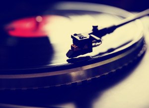 Close up view of old fashioned turntable playing a track from black vinyl toned with a retro vintage instagram filter effect app or action