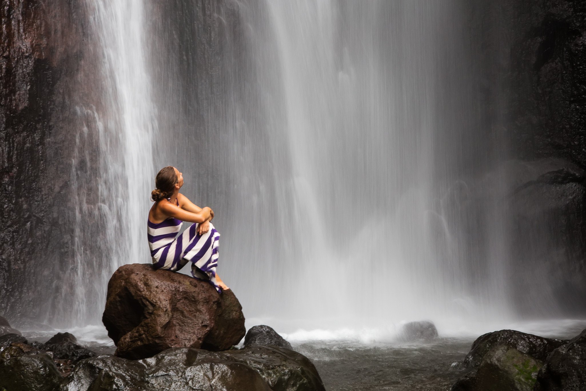 woman meditating doing yoga between beautiful waterfalls