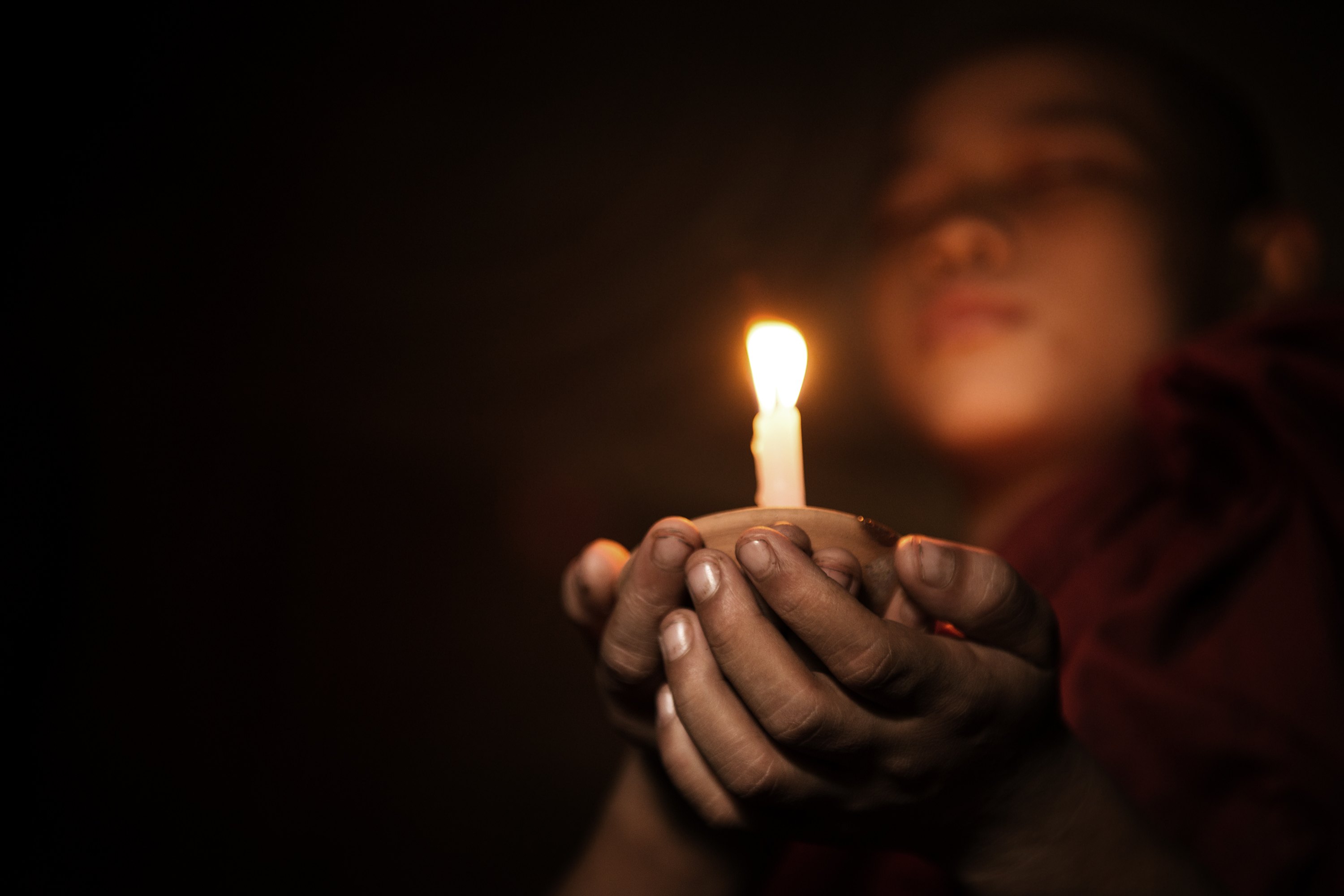 Young novice monk holding a candlelight