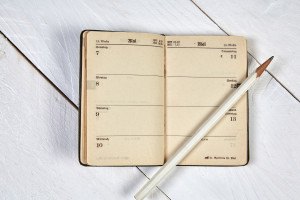 Old calendar and white pencil on a white table